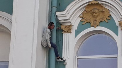 парень на водосточной трубе эрмитажа